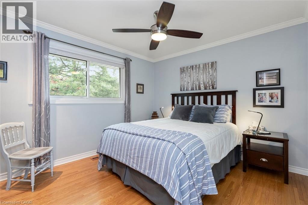 Bedroom 2 with hardwood floor, closet and ample room for dresser, view to front yard - 200 Woodview Crescent, Ancaster, ON