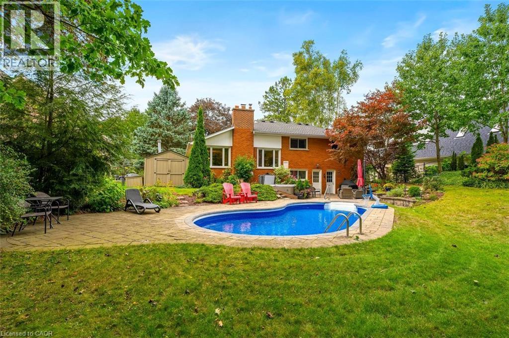 Backyard view highlighting patio surrounding pool and backyard shed - 200 Woodview Crescent, Ancaster, ON
