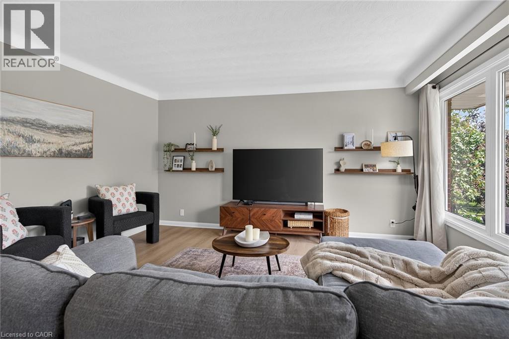 Living area featuring light gray walls with white crown molding and wood-finish flooring - 13 Allanburg Road S, St. Catharines, ON