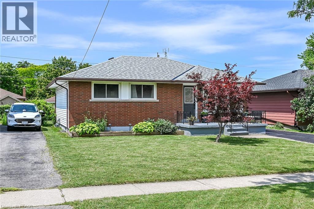 Brick facade bungalow with a gray shingle roof and white eaves - 13 Allanburg Road S, St. Catharines, ON
