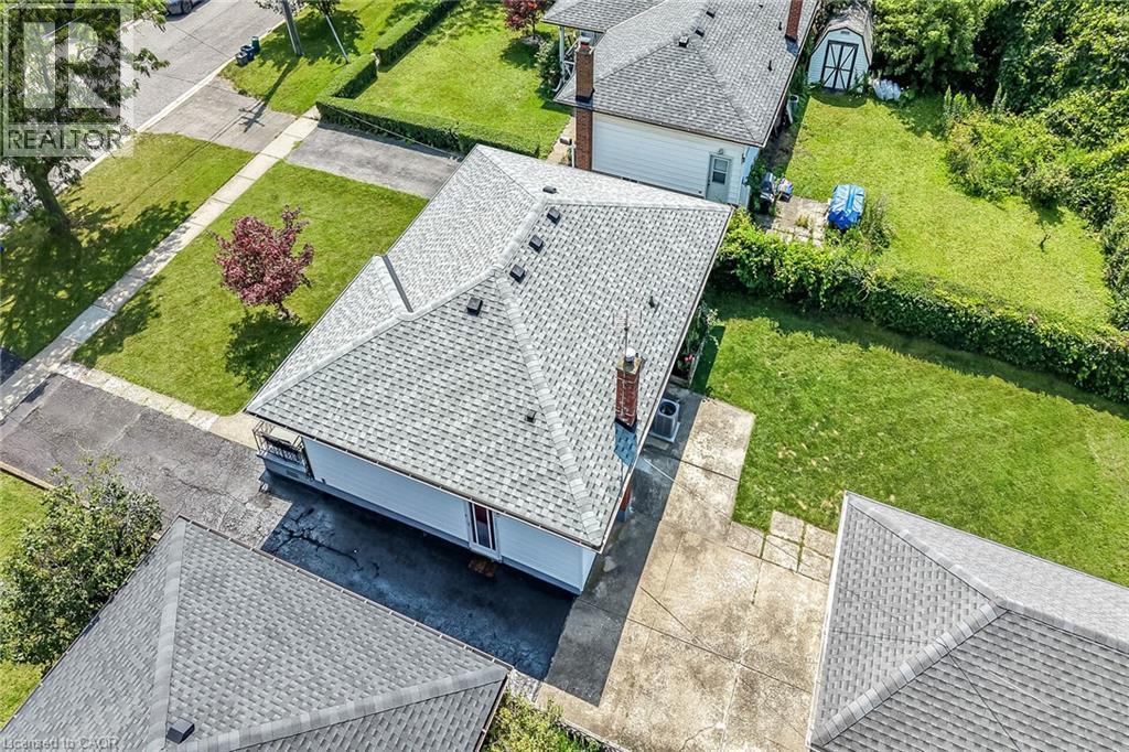 Single-story residence featuring a gray shingle roof and a red brick chimney - 13 Allanburg Road S, St. Catharines, ON