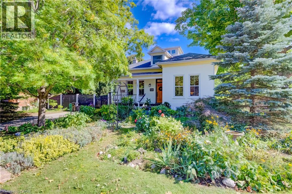 White exterior with a prominent wooden front door, multiple windows, and a dormer - 59 Allen Street W, Waterloo, ON