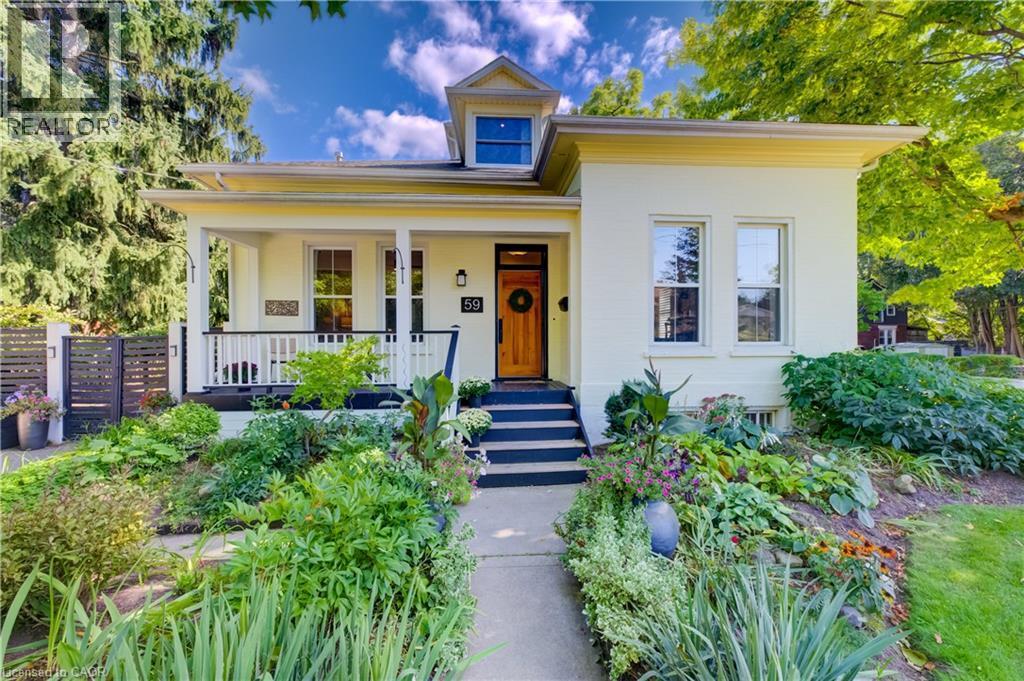 Welcoming front porch, manicured landscaping, light-colored exterior, natural wood-finish front door, and a prominent dormer window - 59 Allen Street W, Waterloo, ON