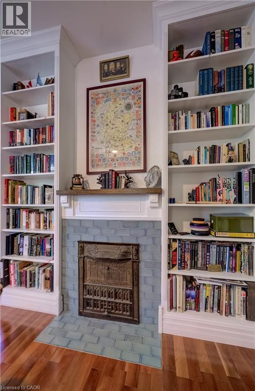 Fireplace with decorative cast iron insert, blue tiled surround, and a classic white mantelpiece - 59 Allen Street W, Waterloo, ON