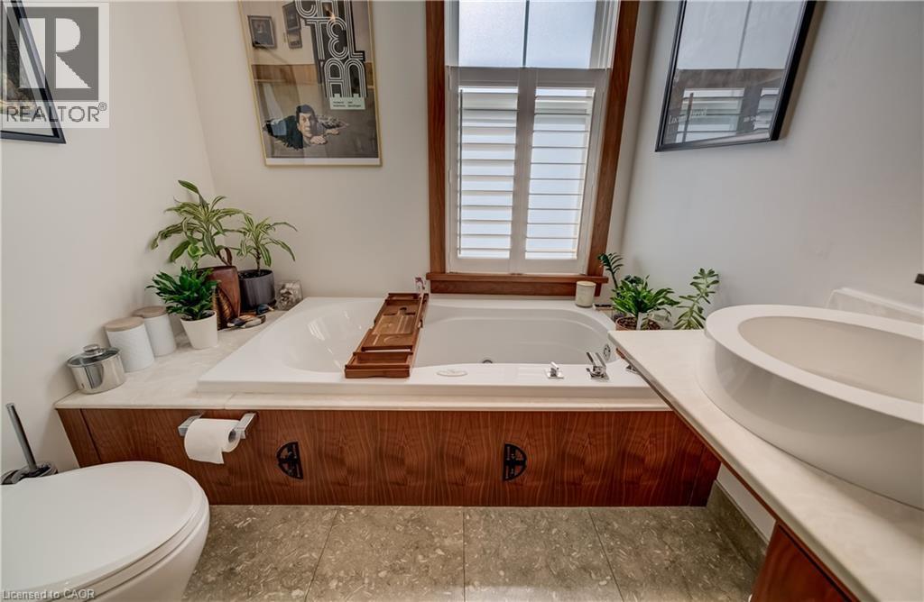 Built-in bathtub with surrounding wood-finish paneling and light-toned countertop - 59 Allen Street W, Waterloo, ON