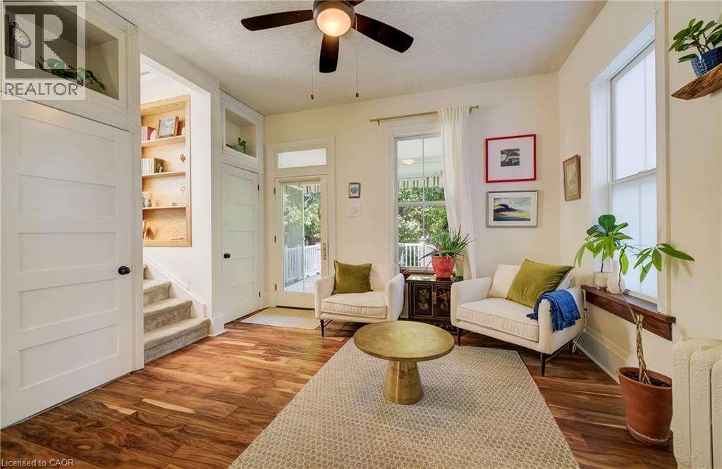 Wood-finish flooring throughout, integrated built-in shelving, two large windows, and a glass-paneled door - 59 Allen Street W, Waterloo, ON