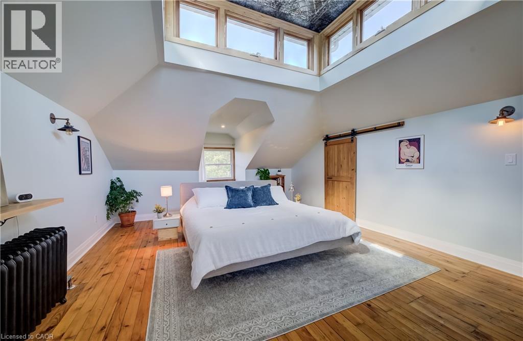 Hardwood flooring, wood-framed windows, exposed wood ceiling, and a sliding barn door - 59 Allen Street W, Waterloo, ON