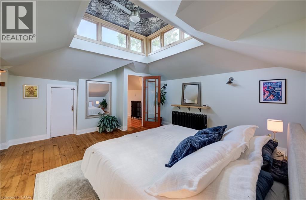 Angled ceilings with a central skylight feature, wood-finish flooring, and a built-in radiator - 59 Allen Street W, Waterloo, ON