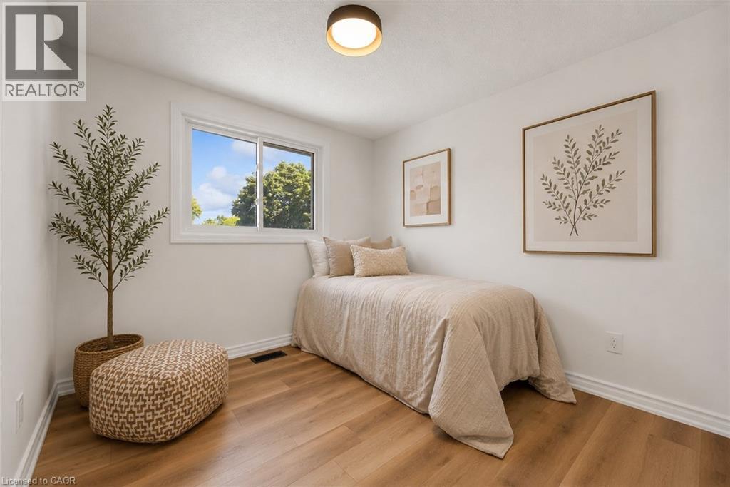 Bright room featuring wood-finish flooring and white baseboards - 49 Grove Avenue, St. Catharines, ON