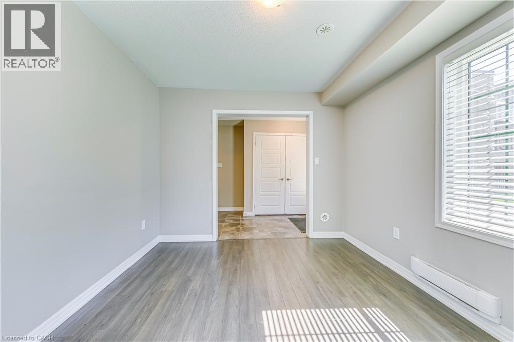Wood-finish flooring, white trim, and a window with blinds - 212 Ellen Davidson Drive, Oakville, ON