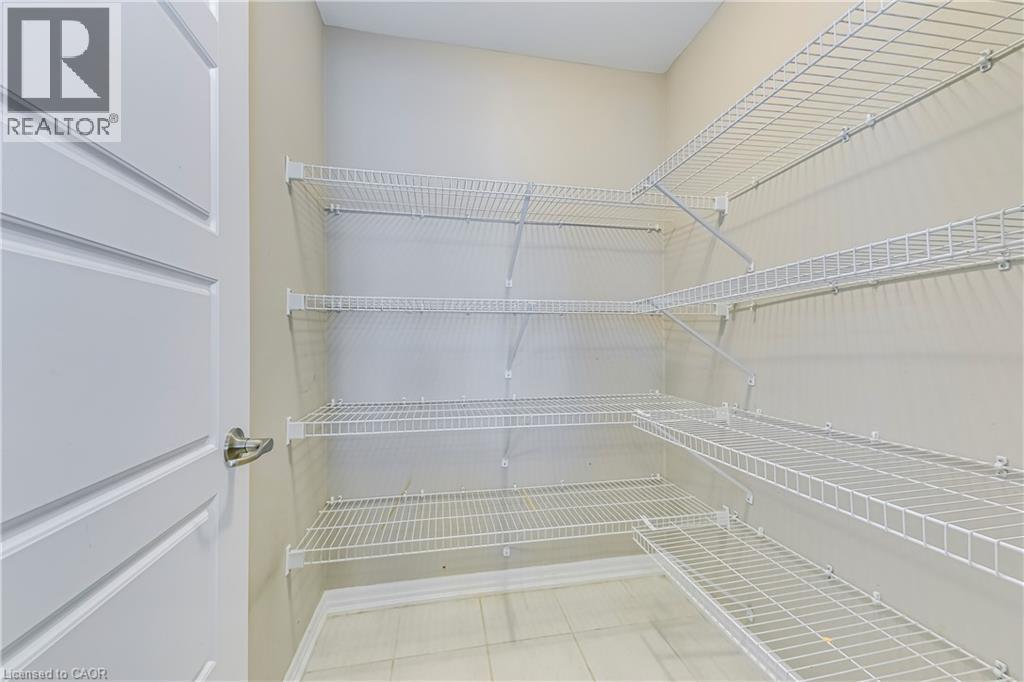Integrated wire shelving system, tiled flooring, and a paneled door with a brushed metal handle - 212 Ellen Davidson Drive, Oakville, ON