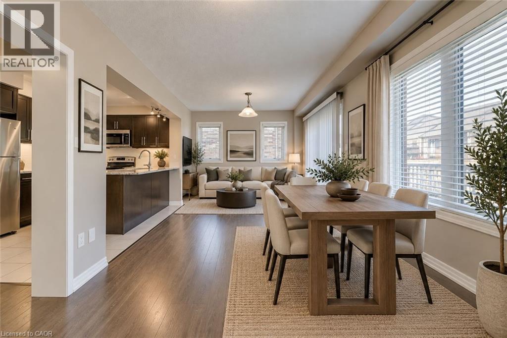 Open-concept living space with wood-finish flooring, a dining area, and multiple windows - 212 Ellen Davidson Drive, Oakville, ON
