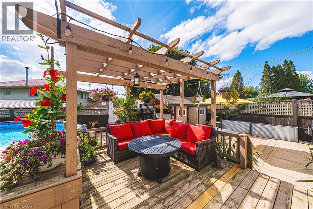 Wood-finish deck with a pergola, an in-ground pool, and privacy fencing - 915 St George Street, Port Dover, ON