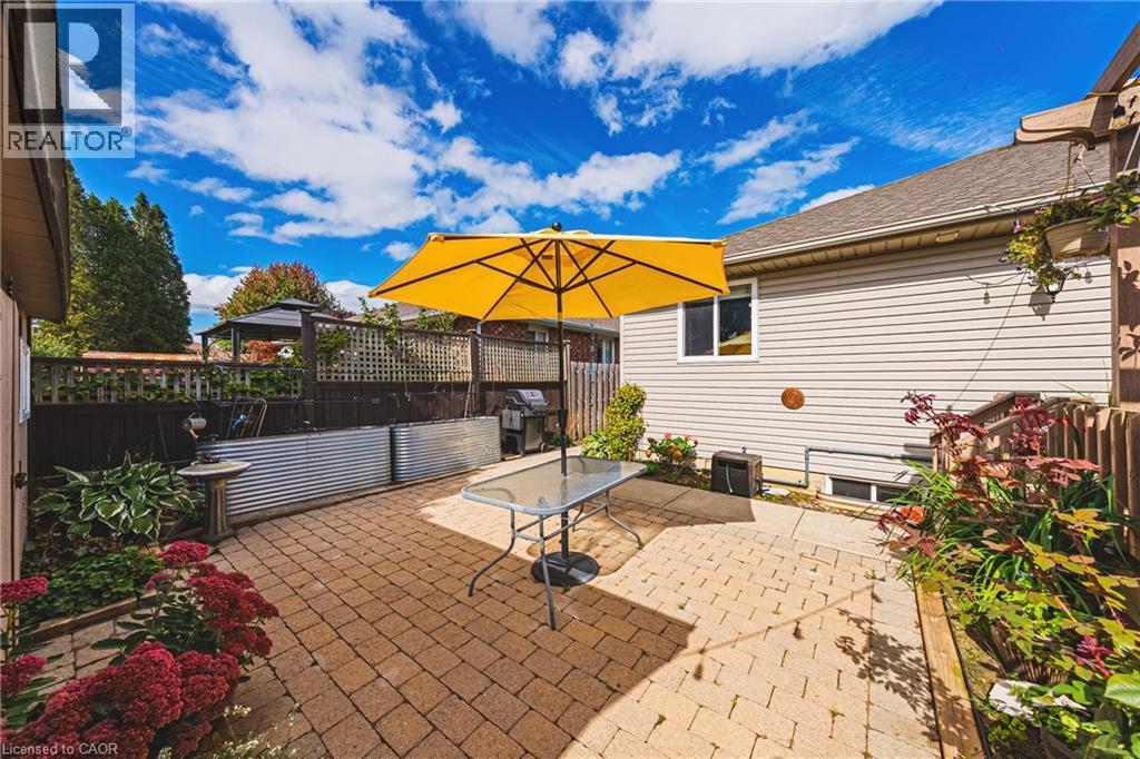 Brick paver patio with perimeter landscaping and raised garden beds - 915 St George Street, Port Dover, ON