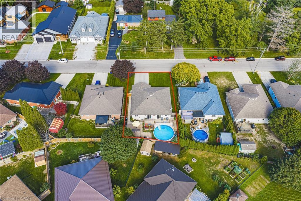 Paved driveway, attached garage, private backyard with an inground pool, and mature landscaping - 915 St George Street, Port Dover, ON