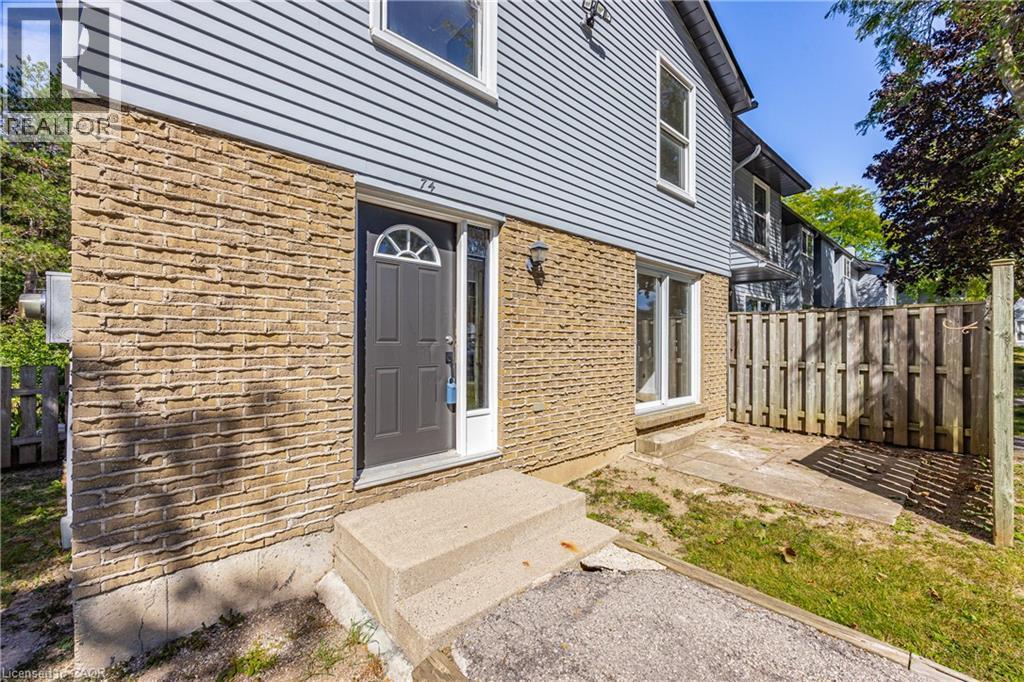 Brick and siding exterior with a dark-paneled entry door, arched transom window, and exterior light fixture - 70 Fiddlers Green Road Unit# 74, London, ON