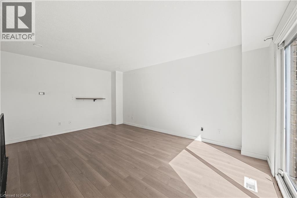 Wood-finish flooring throughout, white painted walls, and a built-in wall shelf - 70 Fiddlers Green Road Unit# 74, London, ON