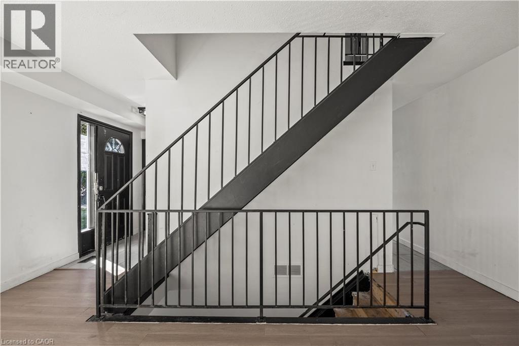 Metal baluster staircase with wood-finish flooring - 70 Fiddlers Green Road Unit# 74, London, ON