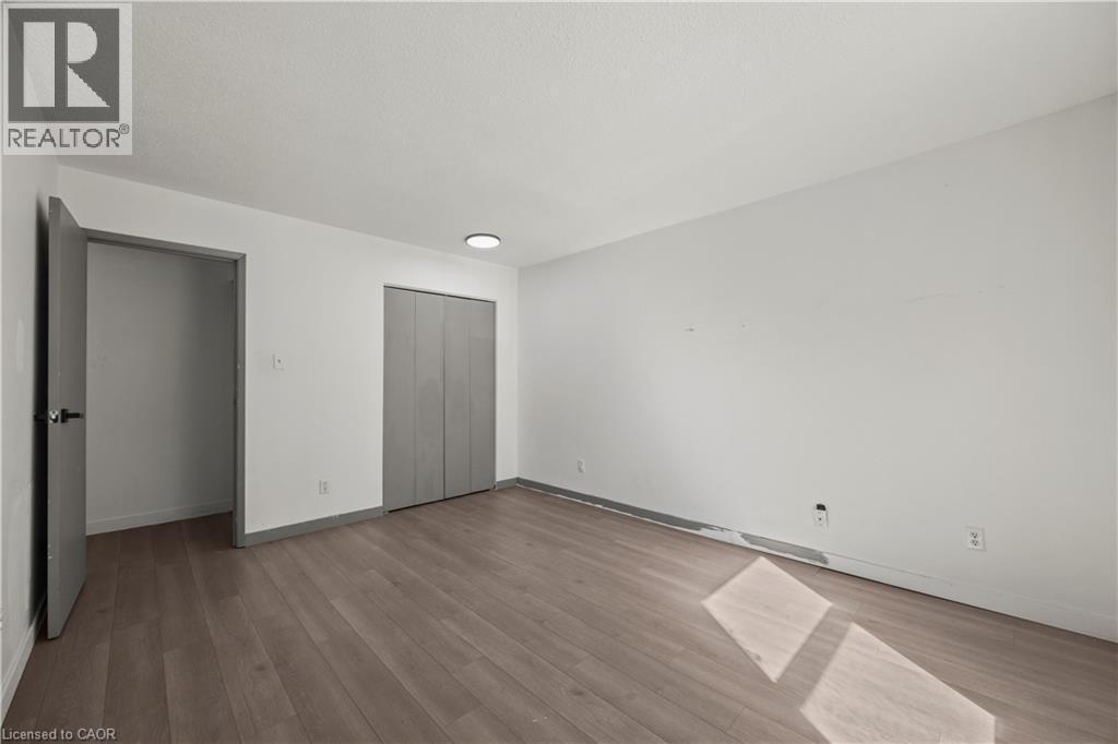 Wood-finish flooring with a neutral white wall finish and gray trim - 70 Fiddlers Green Road Unit# 74, London, ON