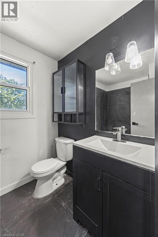 Vanity with white integrated sink, chrome faucet, and dark cabinet - 70 Fiddlers Green Road Unit# 74, London, ON