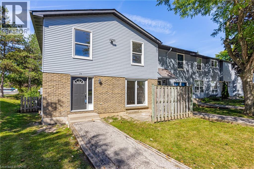 Light blue siding exterior with a dark gray entry door, complemented by a light brown brick facade - 70 Fiddlers Green Road Unit# 74, London, ON