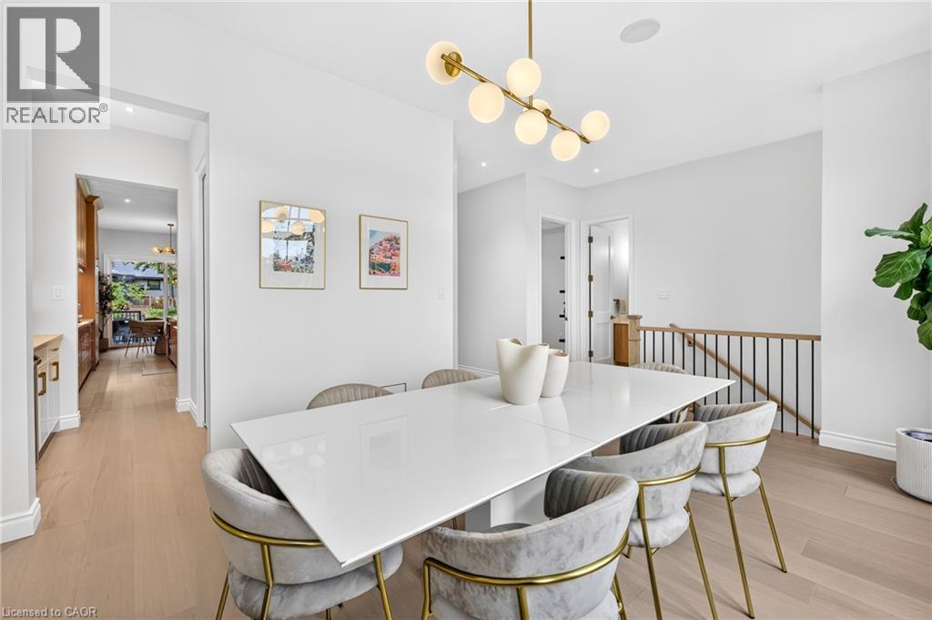 Recessed lighting, wood-finish flooring, white walls, and a modern linear chandelier - 67 Cielo Court, Hamilton, ON