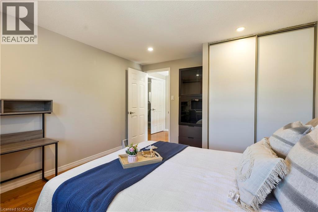 Built-in sliding door closet, recessed lighting, wood-finish flooring, and a paneled interior door - 475 Beechwood Drive Unit# 4, Waterloo, ON