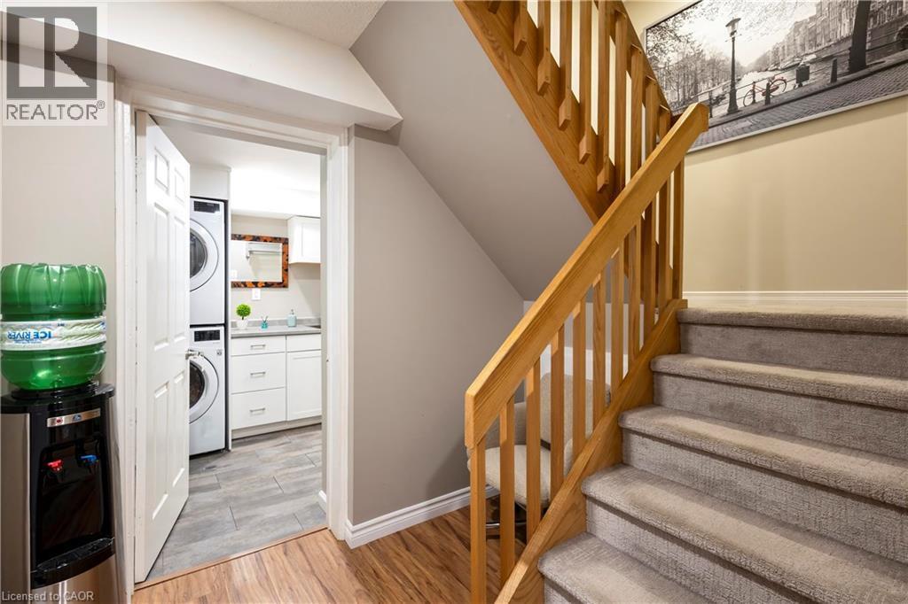 Carpeted staircase with wood railing, leading to an area with wood-finish flooring - 475 Beechwood Drive Unit# 4, Waterloo, ON