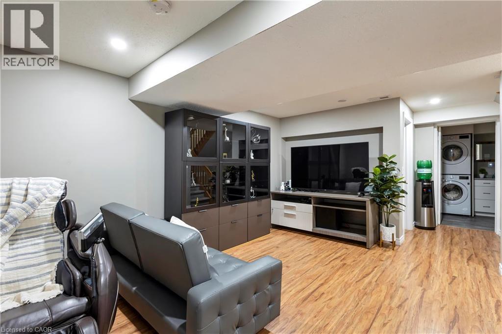 Recessed lighting, wood-finish flooring, built-in storage cabinetry, entertainment console, and stacked laundry appliances - 475 Beechwood Drive Unit# 4, Waterloo, ON