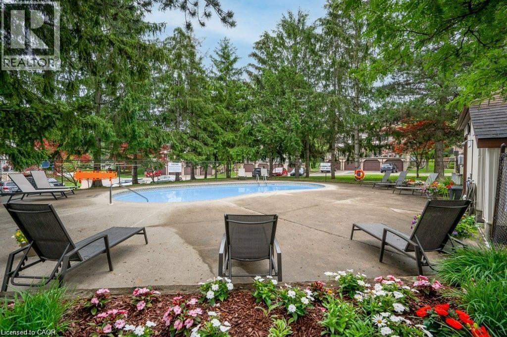 Swimming pool with a concrete surround, surrounded by mature trees - 475 Beechwood Drive Unit# 4, Waterloo, ON