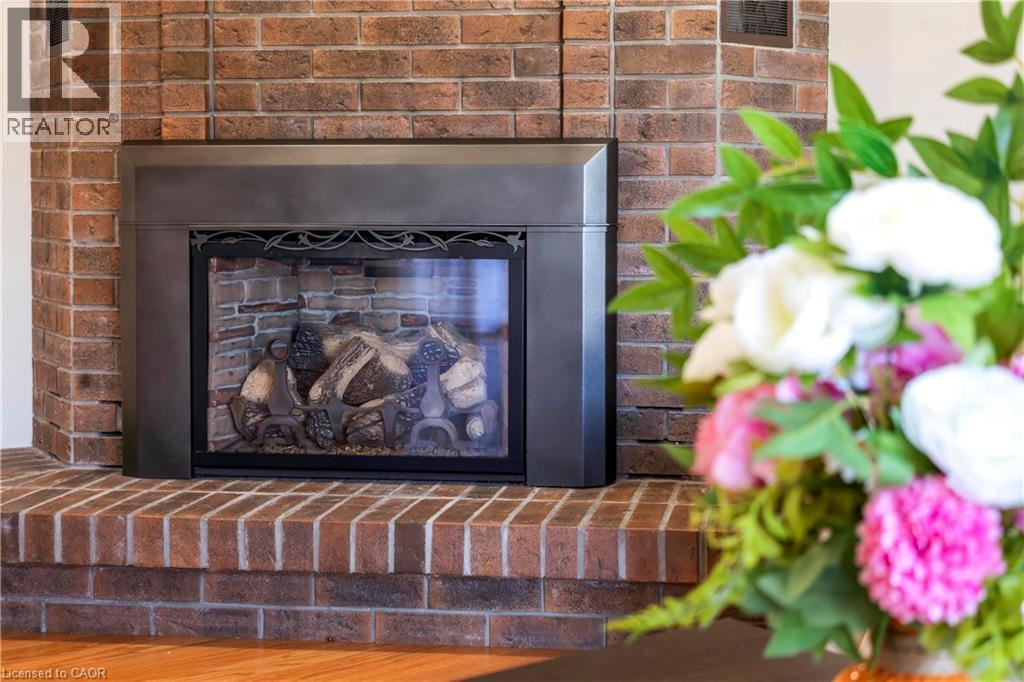 Brick fireplace with a metal insert and decorative wrought iron detailing - 475 Beechwood Drive Unit# 4, Waterloo, ON