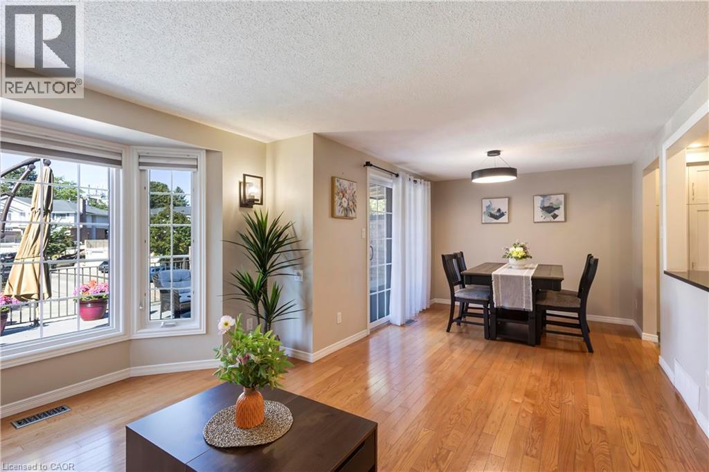 Hardwood-finish flooring, bay window, built-in wall sconce, patio door, and modern overhead light fixture - 475 Beechwood Drive Unit# 4, Waterloo, ON