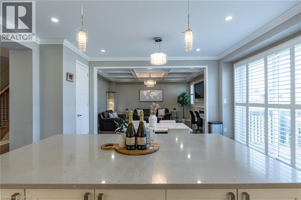 Kitchen island with a light-toned countertop, recessed lighting, and decorative pendant fixtures - 455 Equestrian Way, Cambridge, ON