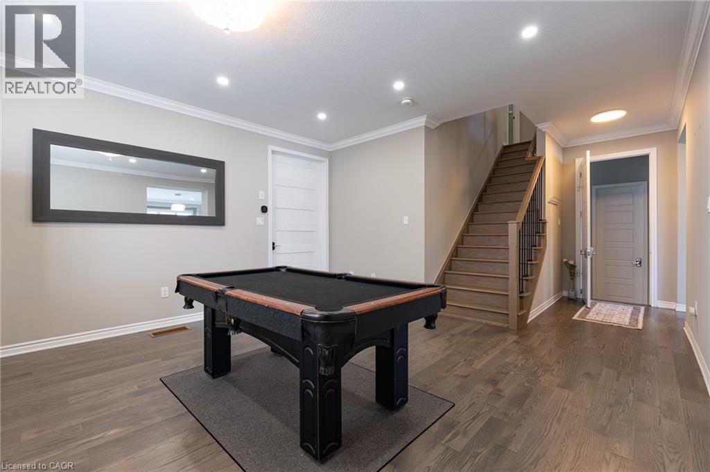 Wood-finish flooring, recessed lighting, crown molding, paneled interior doors, and a wood staircase with metal balusters - 455 Equestrian Way, Cambridge, ON