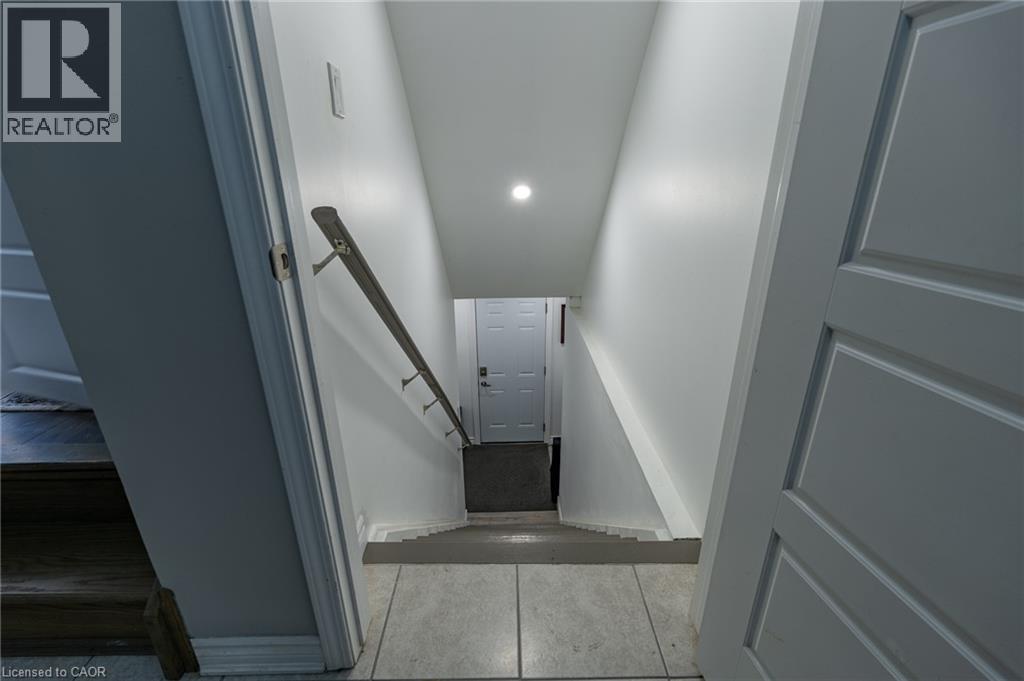 Staircase featuring a metal handrail, recessed lighting, and tile flooring - 455 Equestrian Way, Cambridge, ON