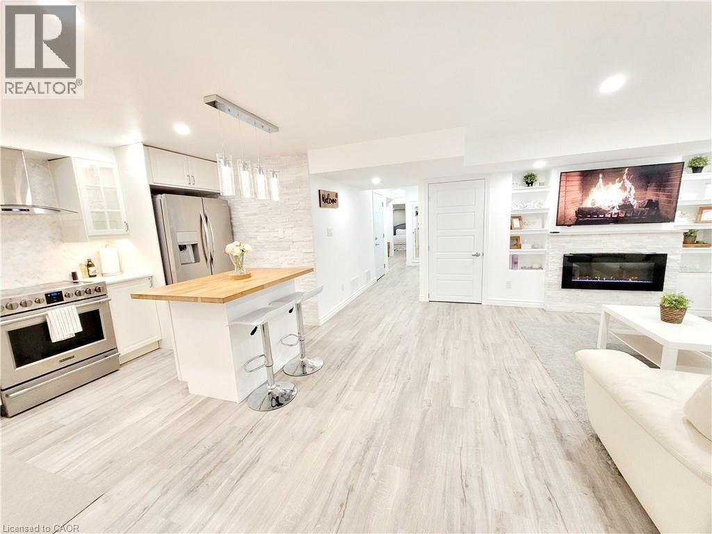 Integrated kitchen and living area with wood-finish flooring - 455 Equestrian Way, Cambridge, ON