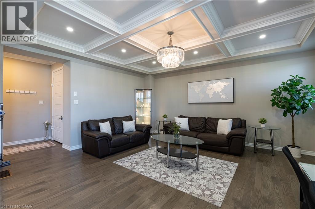 Coffered ceiling with recessed lighting and a crystal chandelier, wood-finish flooring, and white baseboards - 455 Equestrian Way, Cambridge, ON