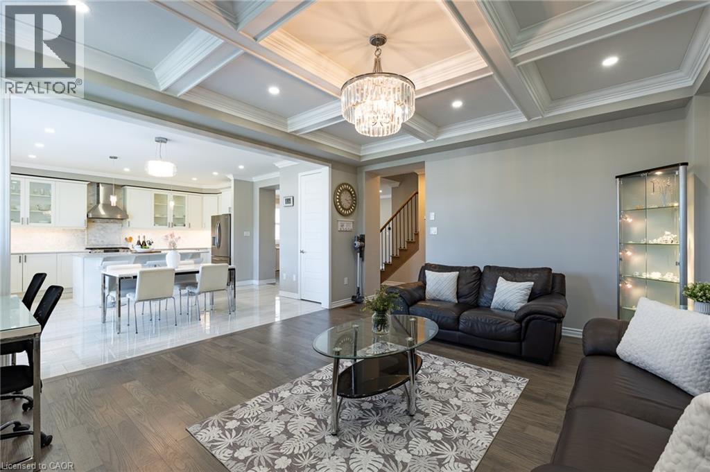 Coffered ceiling with a crystal chandelier, recessed lighting, and wood-finish flooring - 455 Equestrian Way, Cambridge, ON