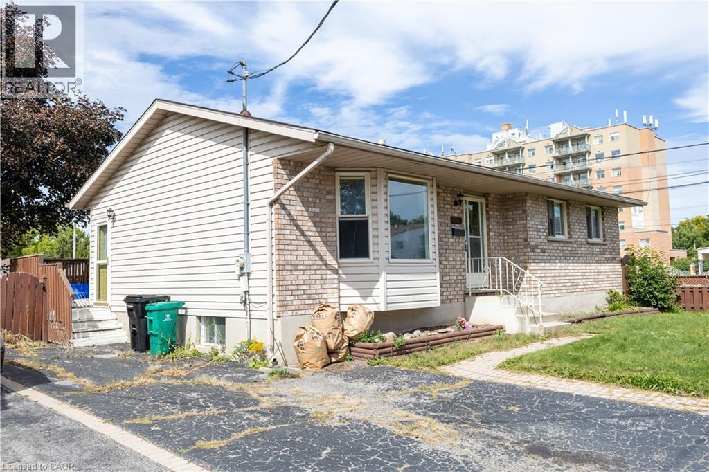 Exterior featuring a brick and siding facade, front entry with storm door, and a bay window - 120 Union Street S, Cambridge, ON