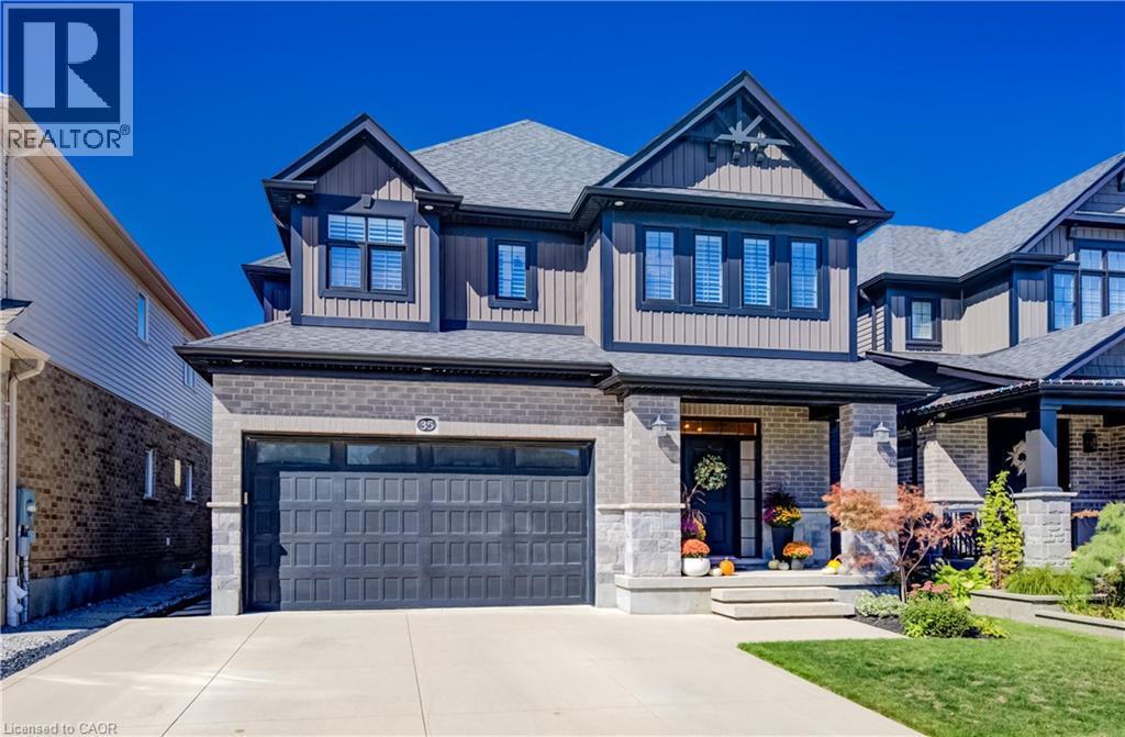 Stone and siding facade featuring multiple gables, an attached two-car garage, and a covered entryway - 35 Greyhawk Street, Kitchener, ON