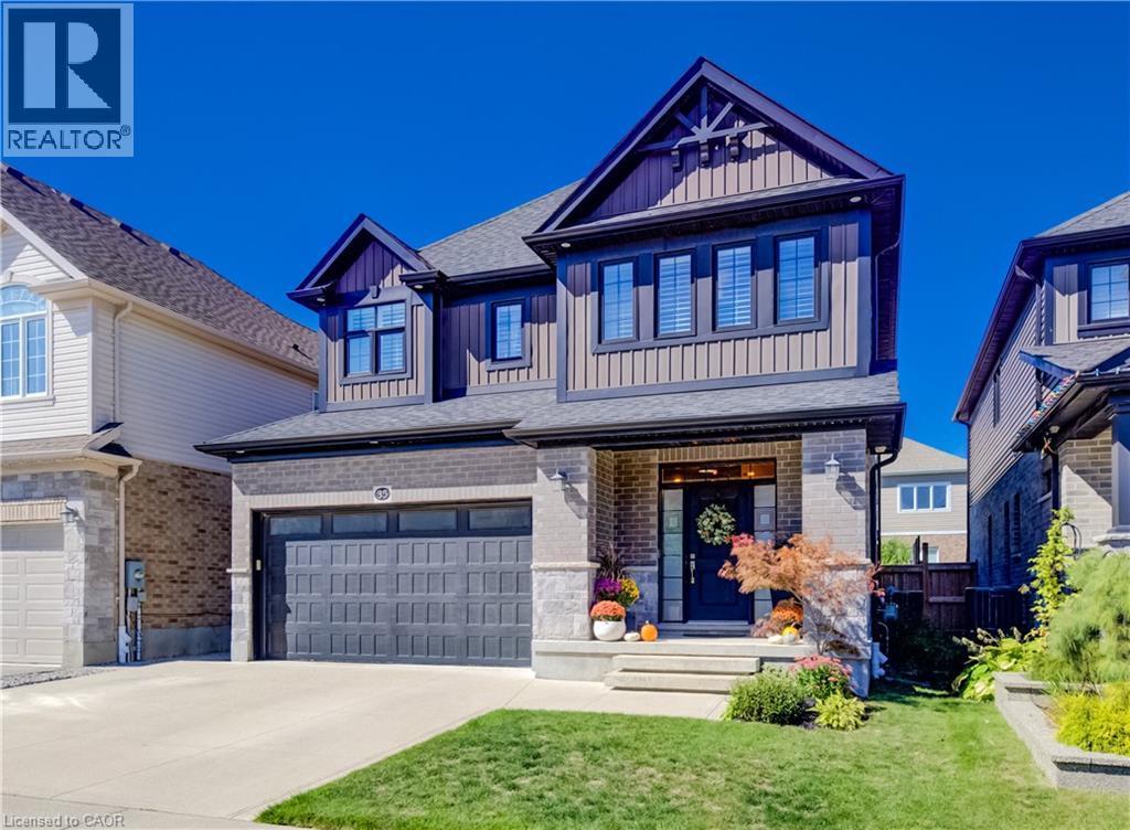 Two-story residence featuring a brick and siding facade, a double-car garage, and a concrete driveway - 35 Greyhawk Street, Kitchener, ON