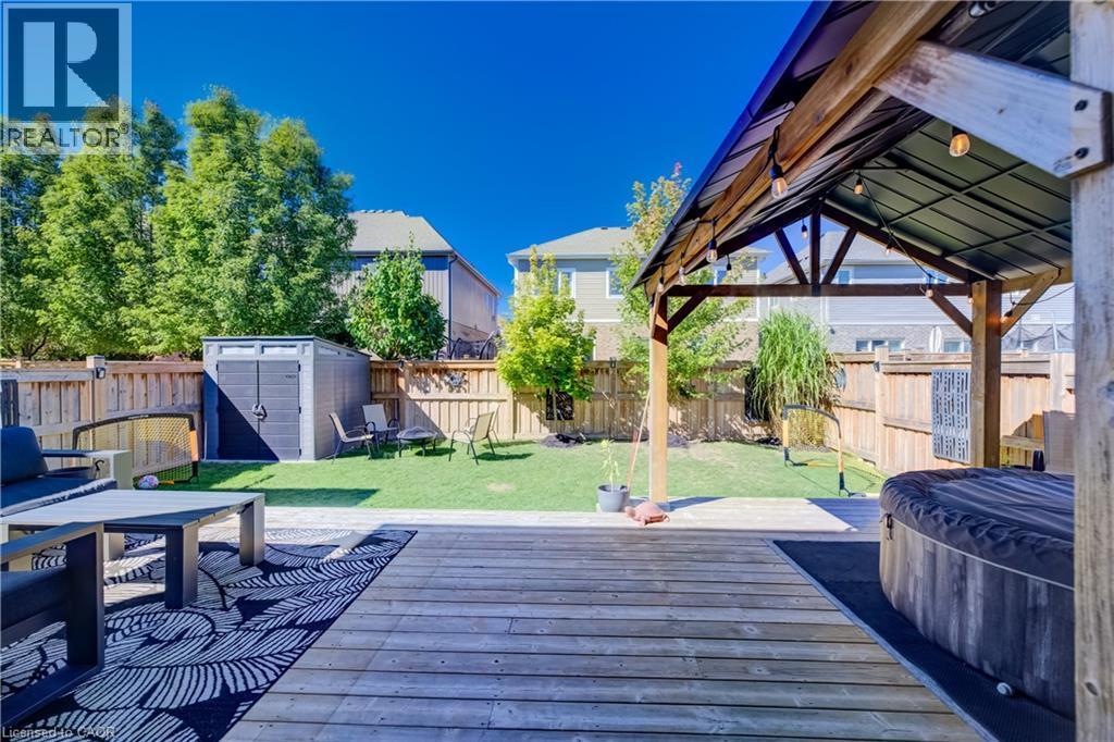 Expansive backyard featuring a wood-finish deck, covered gazebo, and manicured lawn - 35 Greyhawk Street, Kitchener, ON