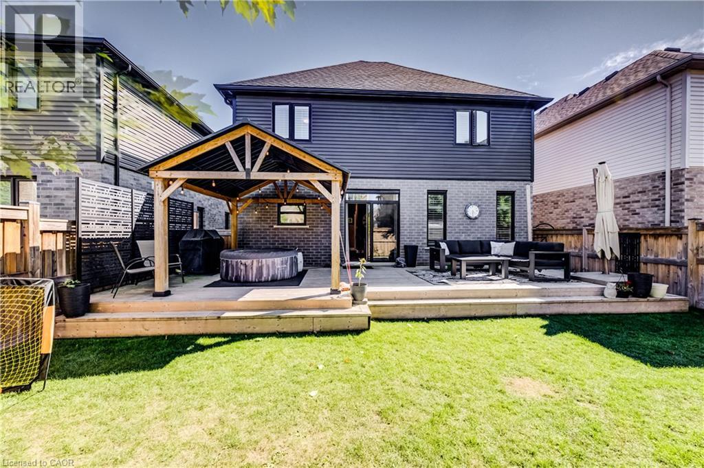 Expansive backyard featuring a manicured lawn, a multi-level deck, a wooden pergola, and a private fenced perimeter - 35 Greyhawk Street, Kitchener, ON