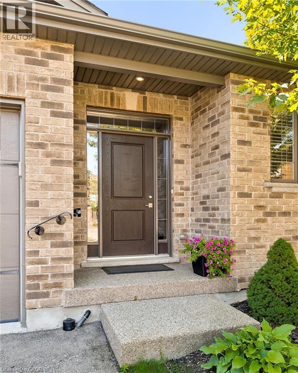 Brick exterior with a prominent brown entry door featuring a transom window - 192 Brewery Street Unit# 18, Baden, ON
