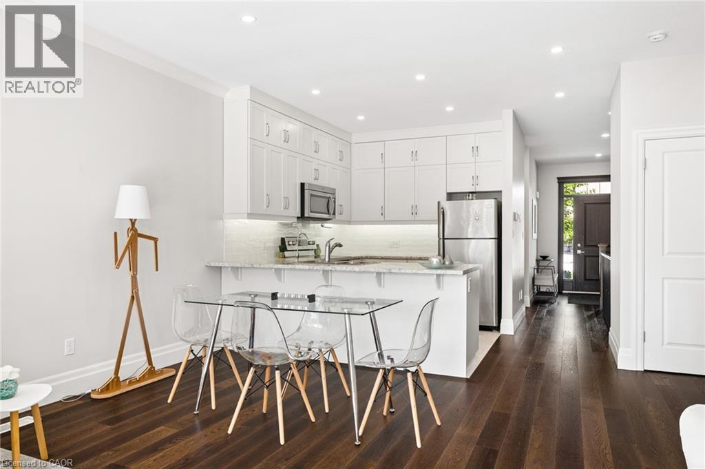 Kitchen featuring white cabinetry, stainless steel appliances, recessed lighting, and a breakfast bar - 192 Brewery Street Unit# 18, Baden, ON