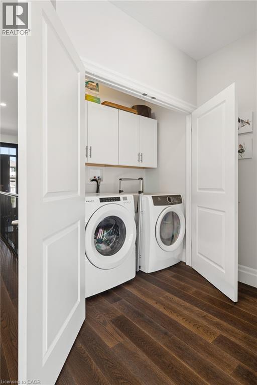 Dedicated laundry area featuring a front-loading washer and dryer, wood-finish flooring, and white cabinetry - 192 Brewery Street Unit# 18, Baden, ON