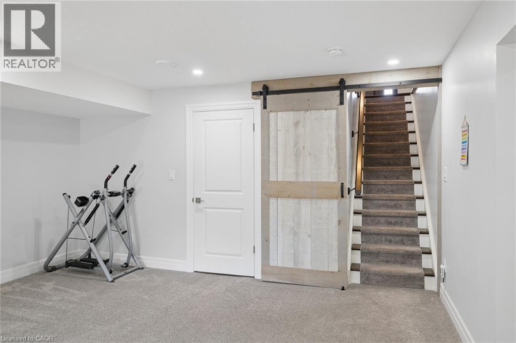 Barn door entry to carpeted stairs, recessed lighting, and a white panel door - 192 Brewery Street Unit# 18, Baden, ON