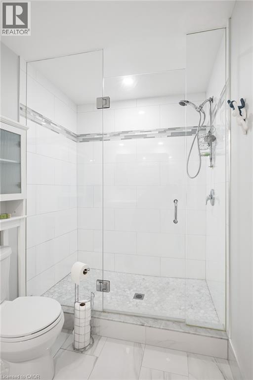 Glass-enclosed shower with a tiled surround, integrated grab bar, and a handheld shower fixture - 192 Brewery Street Unit# 18, Baden, ON