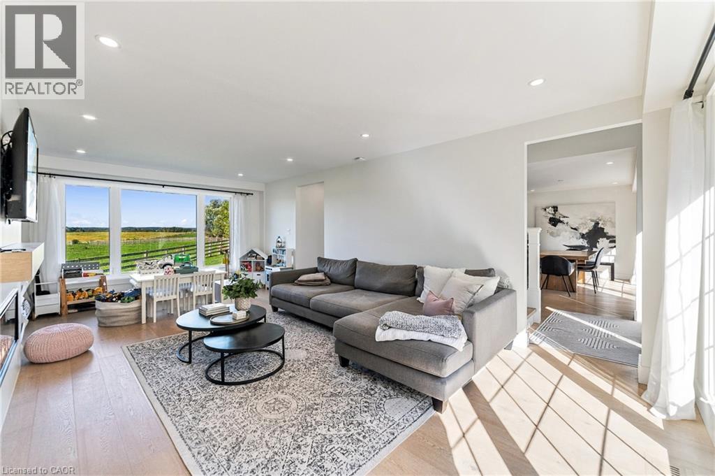 Recessed lighting, wood-finish flooring, large picture windows, and an open doorway to an adjacent room - 5367 2 Side Road, Milton, ON