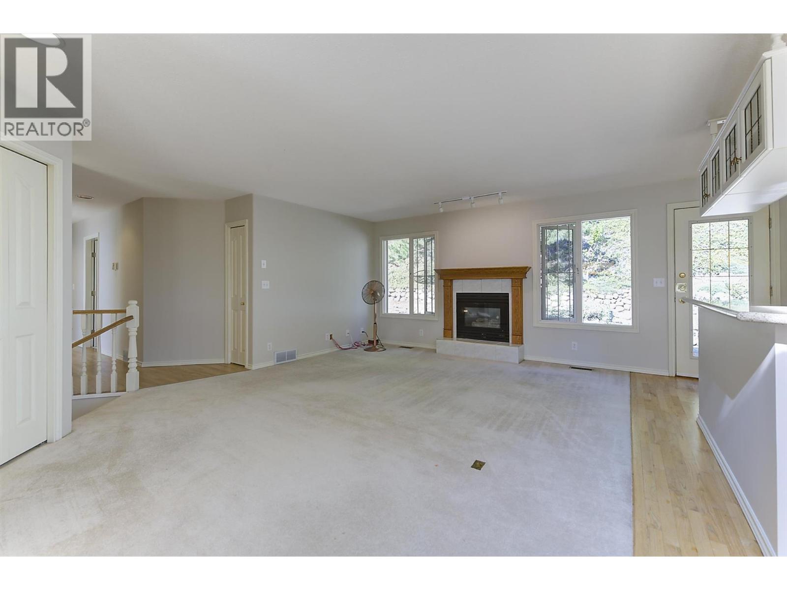 Family room with gas fireplace on the upper level - 4632 / 4624 Minto Street, Peachland, BC